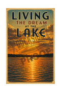 Living the Dream at the Lake vintage poster featuring a lone sailboat silhouetted against a blazing golden sunset over the lake